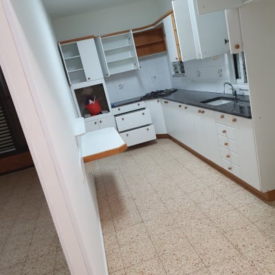 מטבח עם דלי אדום ומוצרי ניקוי