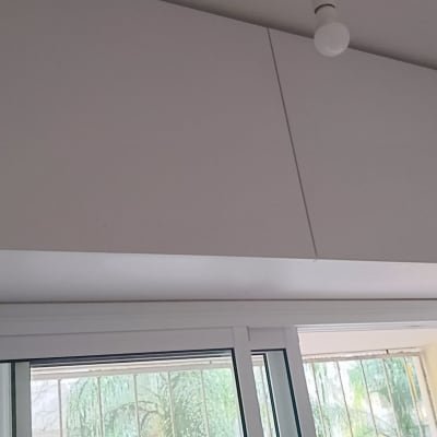 ארון עץ לבן מותקן מעל חלון