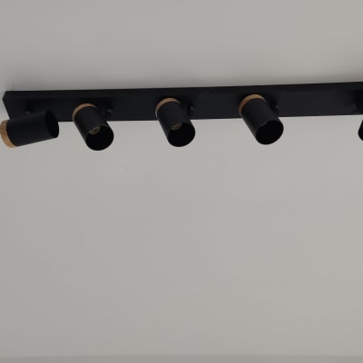 חמישה פנסי תקרה שחורים מותקנים על פס מתכת