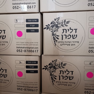 קופסאות קרטון עם מדבקות ורודות ופרטי התקשרות