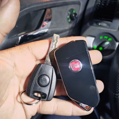 מפתח רכב ושלט פיאט ביד בתוך רכב
