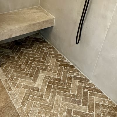 מקלחת עם אריחים בצורת זיגזג וברזים שחורים