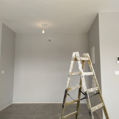 סולם צבוע בצבע לבן בחדר אפור