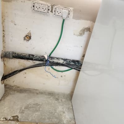 שקעי חשמל עם כבל ירוק מחובר לקיר