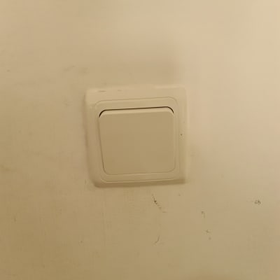 מתג חשמל לבן על קיר בהיר