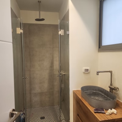 כיור בטון עם ברז מתכת ומגבת קטנה