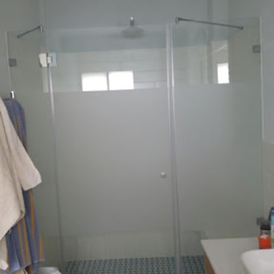 מקלחון זכוכית עם מגבות תלויים בצד