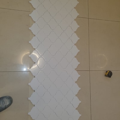 אריחים לבנים מונחים על רצפה, סרט מדידה בצד