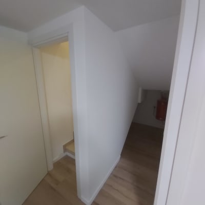 קיר גבס לבן עם פינה חדה ומדרגות עץ