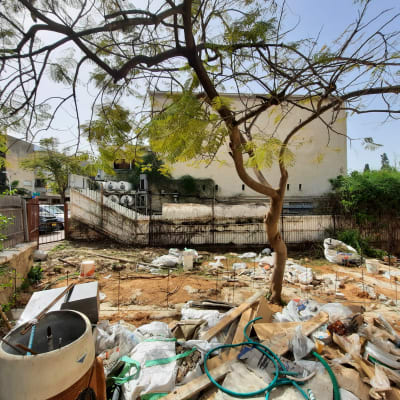 חצר עם עץ, צינורות וכלי גינון