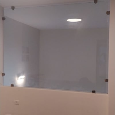 זכוכית מחוברת לקיר עם תפסנים מתכתיים