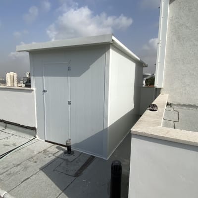 מבנה עץ קטן על גג עם דלת סגורה