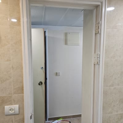 דלי צבע ומברשת ליד דלת פתוחה