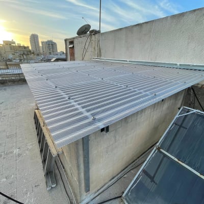 גג עם מסגרת מתכת ולוחות שקופים על מבנה