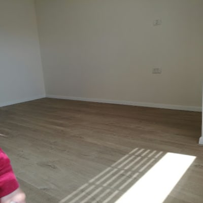 רצפת פרקט עץ בחדר ריק עם קיר לבן