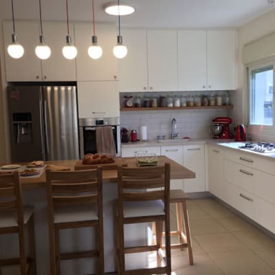 מטבח מודרני עם ארונות לבנים ותאורה תלויה