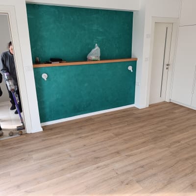 רצפת פרקט עץ בהירה בחדר ריק עם קיר ירוק