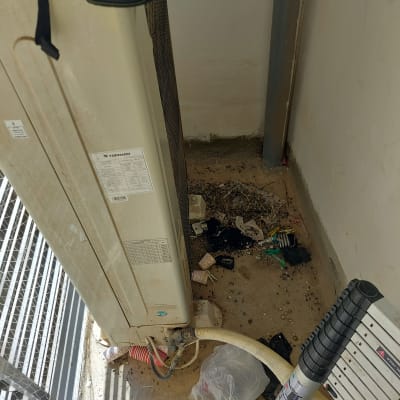 יחידת מזגן חיצונית עם לכלוך ופסולת על הרצפה