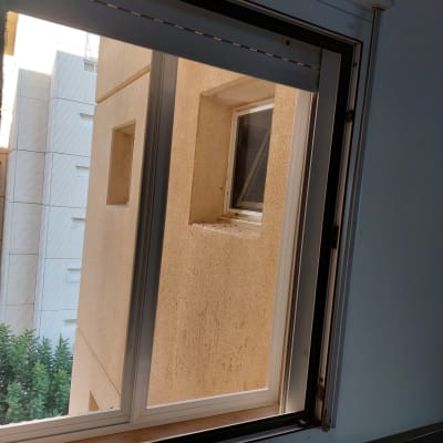 חלון אלומיניום פתוח עם מסגרת לבנה