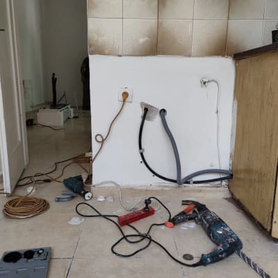 כלי עבודה וצינורות ליד קיר עם אריחים