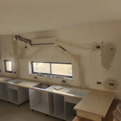 משטחי שיש מותקנים במטבח ללא ארונות עליונים