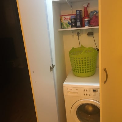 ארון כביסה עם מכונת כביסה וסל כביסה ירוק