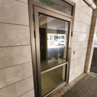 דלת זכוכית עם מסגרת מתכתית בכניסה לבניין