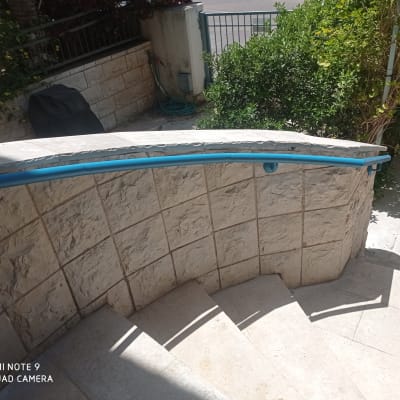 מעקה כחול על קיר אבן במדרגות חיצוניות
