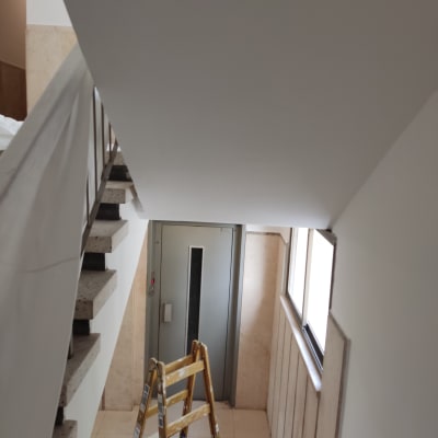 סולם עץ במדרגות ליד קיר צבוע לבן