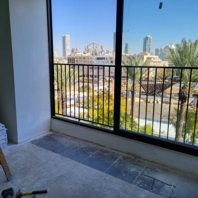 חלון גדול עם מסגרת מתכת ונוף עירוני