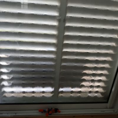 זכוכית חלון עם תריסים סגורים מאחוריה