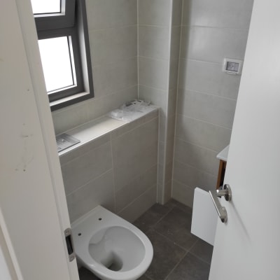 אסלה בחדר אמבטיה עם אריחים אפורים