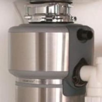 מכשיר טוחן אשפה מתחת לכיור עם צינור פלסטיק