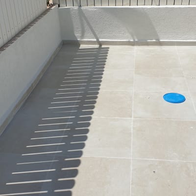 מרפסת עם אריחים אטומים ומטאטא כחול