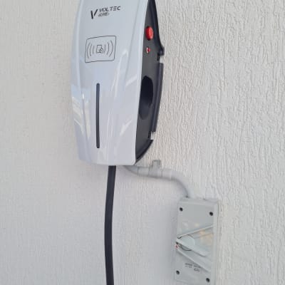 מטען חשמלי לרכב מותקן על קיר עם כבל חשמל