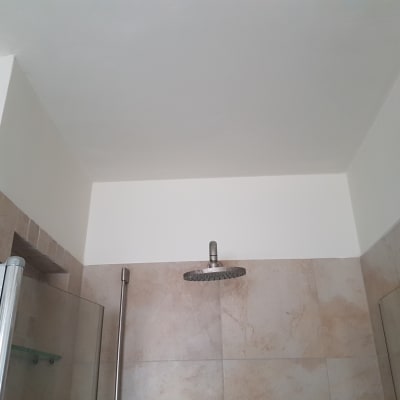 קיר ותקרה צבועים בלבן בחדר אמבטיה