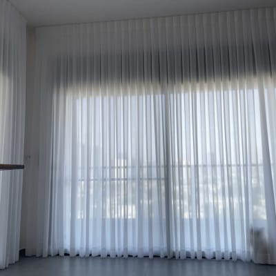 וילון לבן שקוף תלוי על חלון גדול