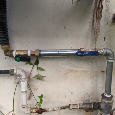 צינורות מתכת עם ברזים ומחברים על קיר חיצוני