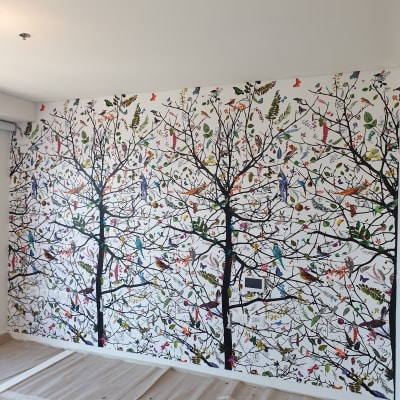 טפט עם עצים, ציפורים ופרחים צבעוניים על קיר