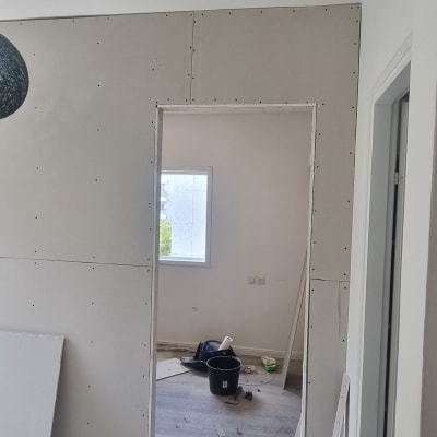 קירות גבס, כלים וחומרים על רצפה במהלך שיפוץ