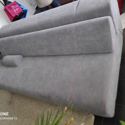 ספה אפורה עם ריפוד מרופד וכרית קטנה