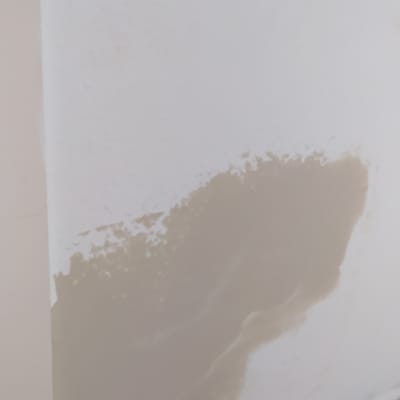 קיר עם תיקון טיח וחתיכות טיח על הרצפה