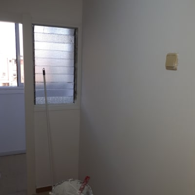 דלי צבע עם רולר ומגש ליד קיר צבוע