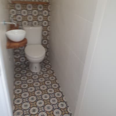 שירותים עם אריחים מעוצבים על הרצפה והקיר