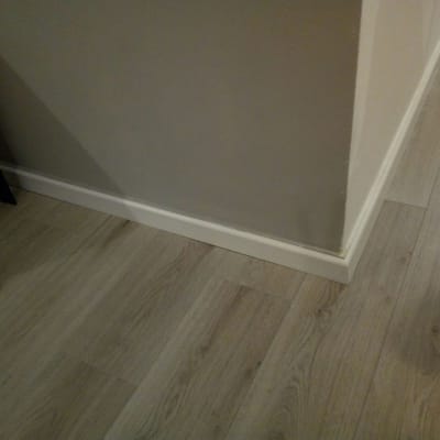 רצפת פרקט עץ בהירה ליד קיר עם פנל לבן