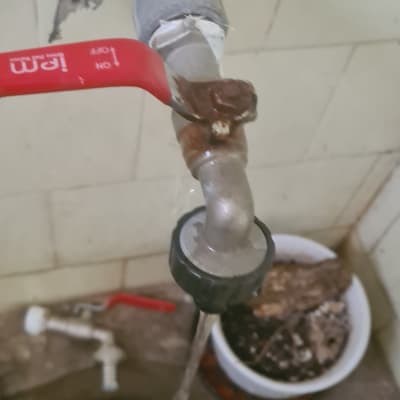 ברז מים עם ידית אדומה, צינור חלוד