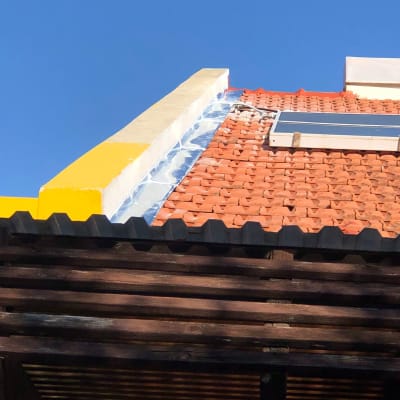 גג רעפים אדומים עם לוח סולארי קטן