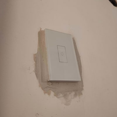 מתג חשמלי מותקן על קיר עם טיח חשוף