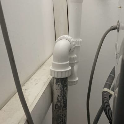 צינורות פלסטיק לבנים מחוברים לקיר