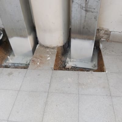 התקנה ועיגון של עמודי מתכת לתשתית הרצפה במהלך שיפוץ